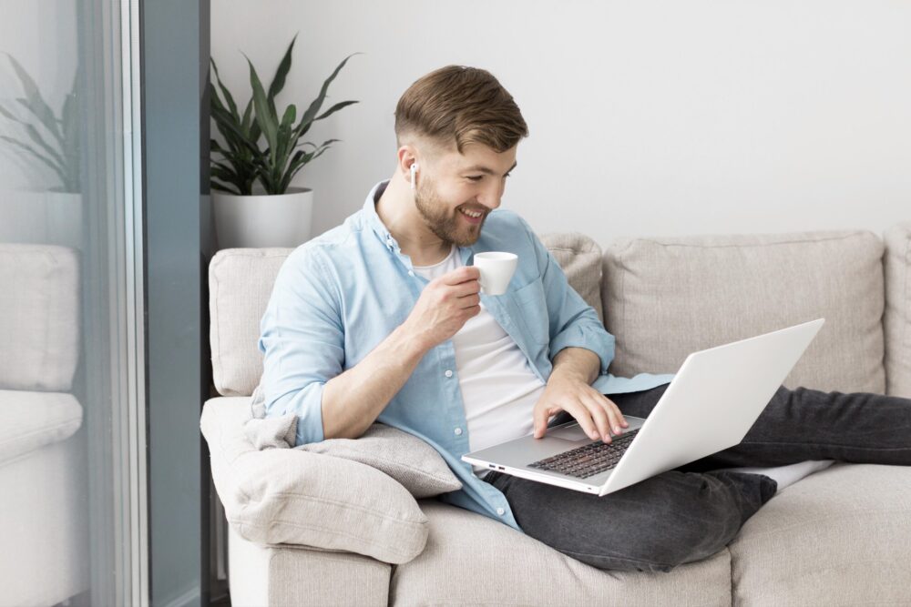 hombre-tomando-cafe-y-usando-laptop hombre-tomando-cafe-y-usando-laptop